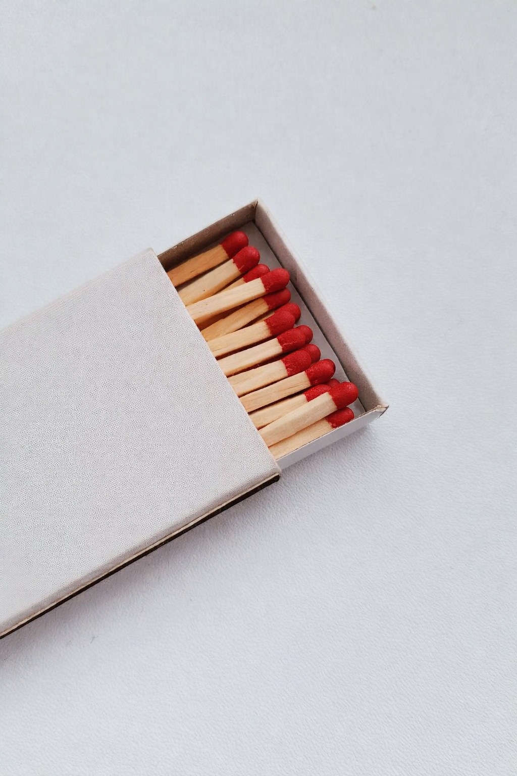 Open matchbox with matches on a light gray background